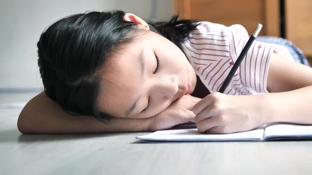 Young Asian girl drawing on floor at home, lifestyle concept.