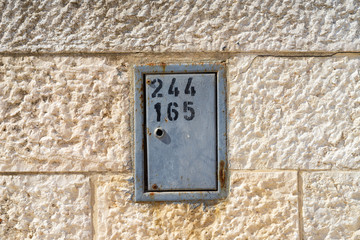 Grey box with numbers on the side of a house
