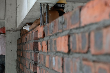 plasterer making up a brick wall with cement