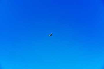 Naklejka na ściany i meble Airplane centered on a bright blue sky