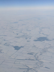 Flying above Ukraine with lots of frozen lakes and a snow covered ground from above