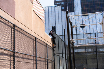 Flushing New York/USA - February 14, 2018: Man climbing a fence at a basketball court
