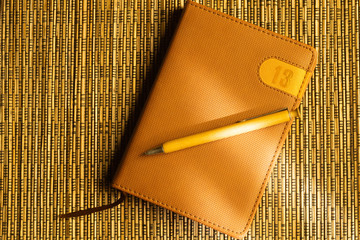 Diary and pen on a wooden bamboo background. notebook and pen top view. number 13