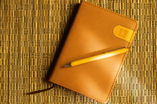Diary and pen on a wooden bamboo background. notebook and pen top view. number 13