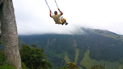 Young man having fun on the swing at the end of the world located at Casa Del Arbol, The Tree House...