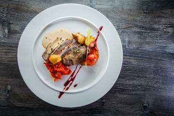 top view of baked meat pieces with grilled vegetables