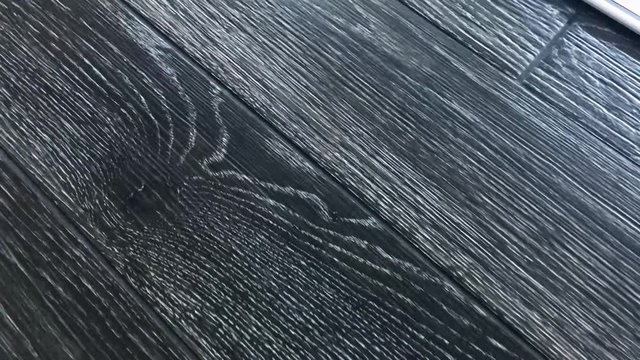 Video clip of hardwood floor slow motion, wood flooring boards are made of natural wood and it is in gray dark color grains