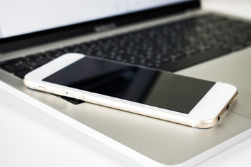 Close-up to the image of the smartphone on the laptop desk.