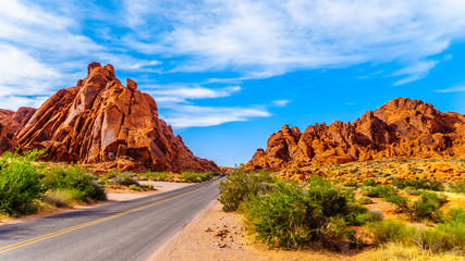 The Mouse's Tank Road surrounded by Red Aztec Sandstone Mountains in the Valley of Fire State Park in Nevada, USA