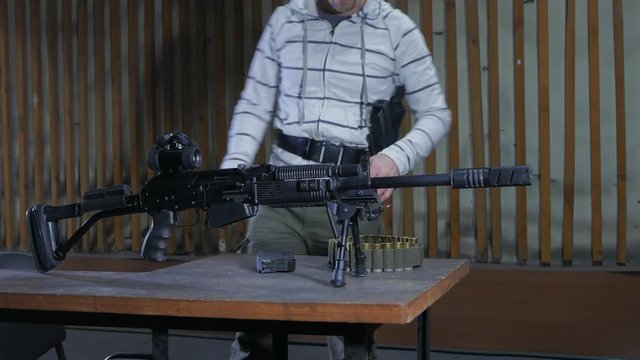 A man in a shooting range loading the 12th caliber Vepr-12 carbine. Shooting training at the shooting range.