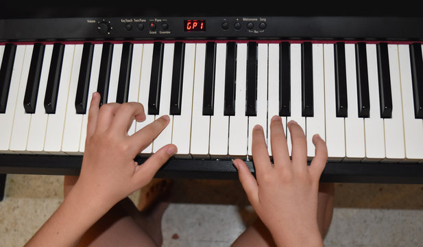 hands of a child playing piano