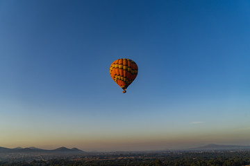 Fototapeta na wymiar Hot air balloon high in the bright blue sky