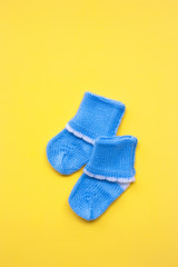 Baby socks on yellow background.