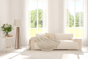 Stylish room in white color with sofa and summer landscape in window. Scandinavian interior design. 3D illustration