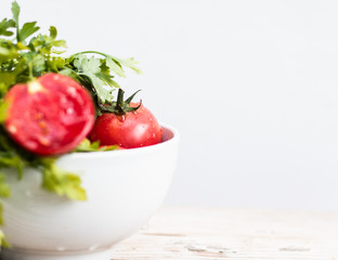 Fresh tomatos and herbs on wooden background. Summer salad.