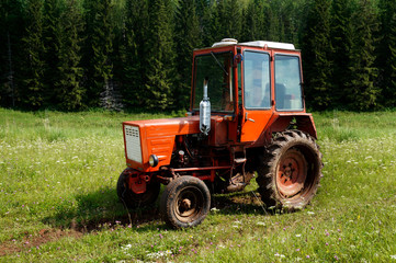 Obraz premium Country road and a tractor in the field on a summer day