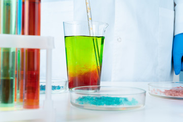 Manipulations with laboratory glass chemical containers on table