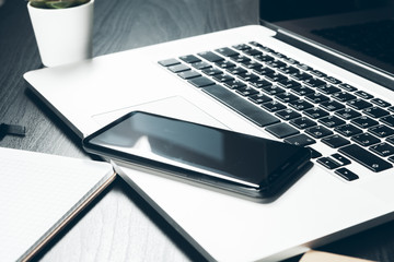 Smartphone and computer keyboard on office table close up