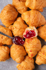 french croissants and spoonful of fruit jam