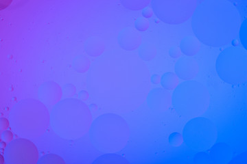 bright oily drops in water with colorful background, close-up 