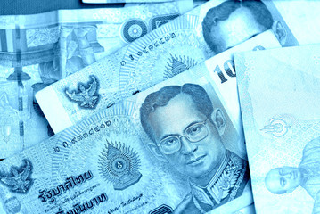Naklejka premium Various banknotes thai baht close up. Money background blue color toned