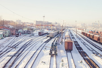 Fototapeta na wymiar Freight trains under snow on winter cargo terminal