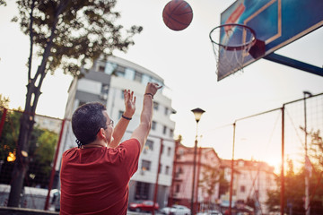 Man taking a shot on a basketball court.