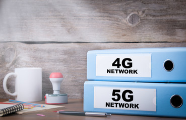 5G and 4G network. Two binders on desk in the office. Business background