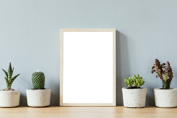 Minimalistic room interior with mock up photo frame on the brown wooden table with beautiful cacti...