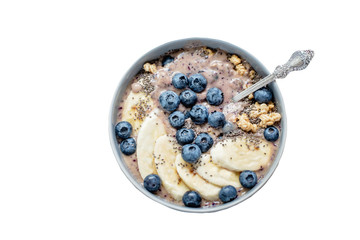 Healthy breakfast berry smoothie bowl topped with banana, granola, Blueberries and chia seeds with copy space