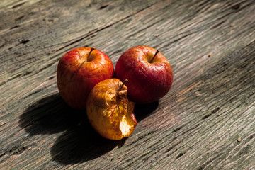 red  withered Apple on a wooden table.