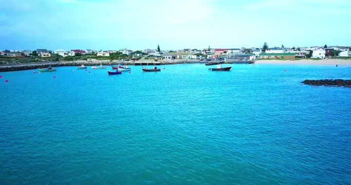 Flying towards a fishing village and harbor on the South African coast, drone