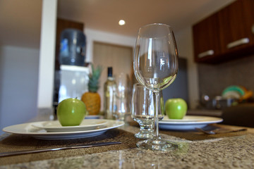 Wine glass on the table close-up. Cutlery in the background.