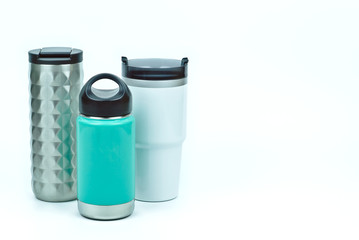 Isolated of three types of eco friendly and zero waste sport thermos stainless steel water bottles in teal white and silver color with black caps on white background with copy space on the right