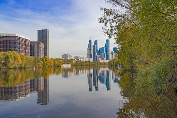 Autumn cityscape. Business center Moscow-city and surroundings. View of skyscrapers, new buildings and residential areas of the Russian capital. Reflections in the water of the Moscow River.