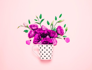 Cup of coffee abd beautiful flowers on pink background.