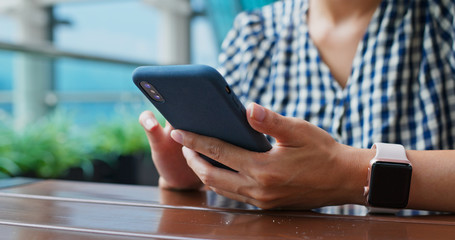 Woman use of mobile phone at outdoor restaurant