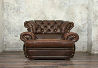 Old vintage brown leather chair in empty room