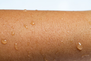 Fototapeta premium Woman's wet arm with water drops on white acrylic background, Close up & Macro shot, Selective focus, Asian Body skin part, Relaxing Bath, Healthcare concept