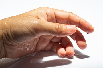 Woman's wet side hand with water drops on white acrylic background, Close up & Macro shot,...