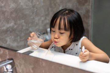 Asian Little Chinese Girl brushing her teeth