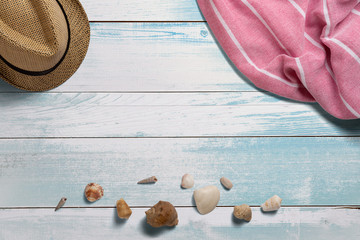 Towel. Scarf. Cover for picnic. Straw hat. Seashells. Summer travel concept elements. On turquoise wooden table. Top view.