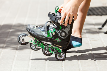 Fototapeta na wymiar Young woman putting roller skates on