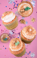 Delicious and fragrant cupcakes with cream on a pink background
