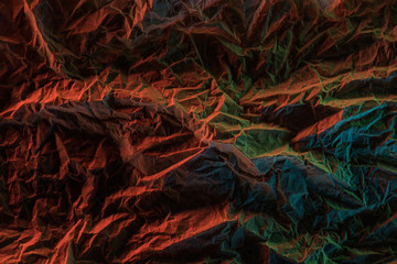 top view of crumpled paper with colorful lighting in dark