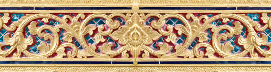 Pattern of gold flower carved on stucco design of native wall, Thai style in temple