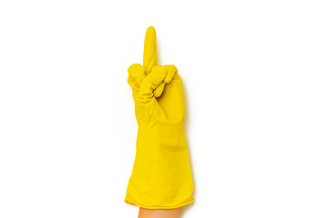 A hand in a yellow rubber glove shows an obscene gesture of Fuck you. Isolated on white background yellow glove. A hand in a bright yellow latex glove on a white background shows an obscene gesture.