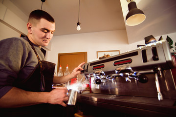 Barista preparing coffee in a coffee shop. Professional coffee making, service and catering concept
