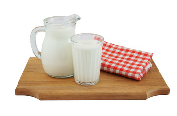 Milk in jug and glass on wooden board isolated