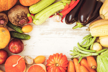 Healthy food background with autumnal vegetables and fruits. Autumn fruits vegetables and leaves. Thanksgiving day concept. Top view. Copy space